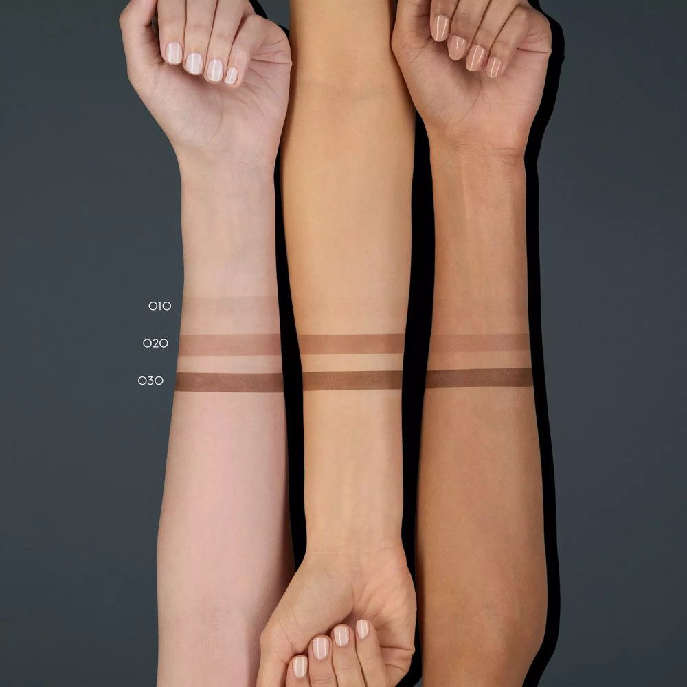 Drie armen met verschillende huidtinten tonen drie tinten wenkbrauwfixeermiddel. De kleuren zijn gelabeld.