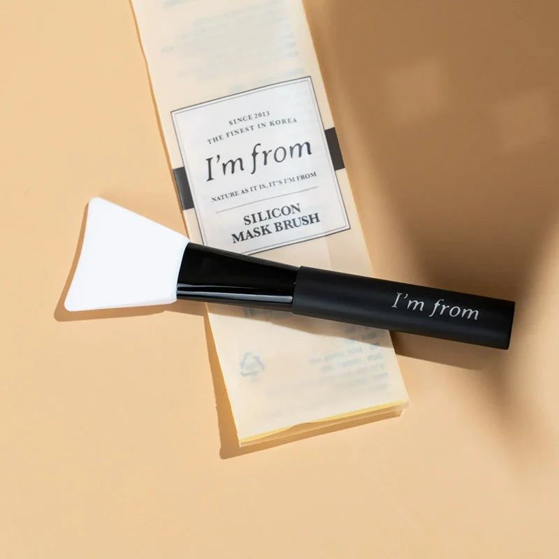 Siliconen spatel en verpakking. Zwarte handgreep met "I'm from" tekst. Witte spatelkop. Verpakking met logo.