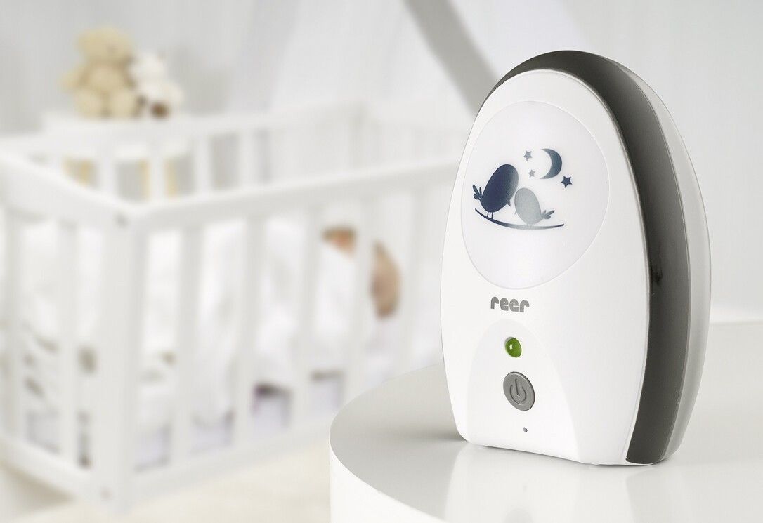 Babyphone avec veilleuse à côté d'un lit d'enfant.