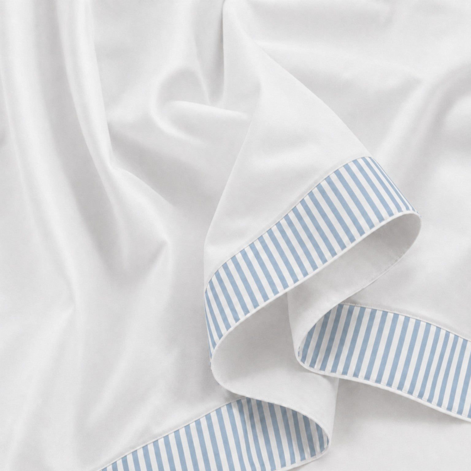 Wit laken met een rand van blauw-witte strepen, close-up.