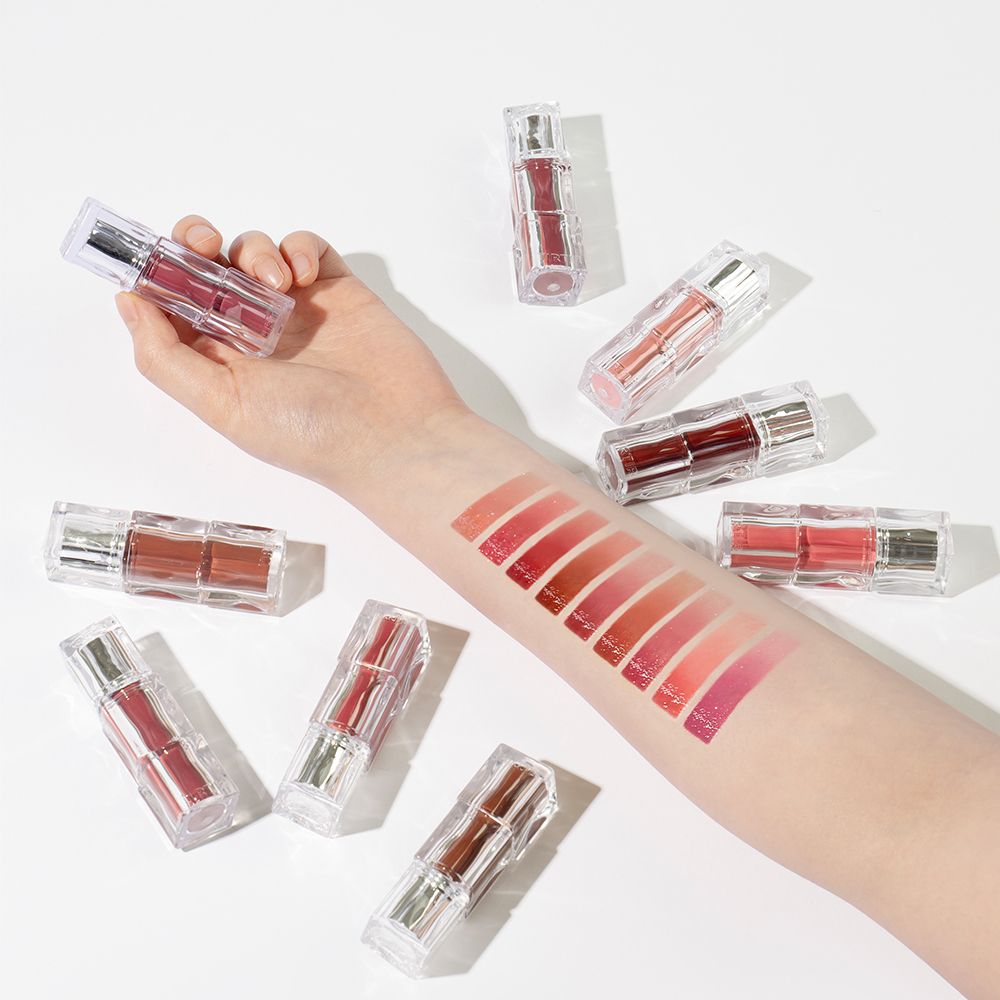 Hand met aangebrachte lippenstift-swatches en meerdere TINTIR Waterism Glow Tints.