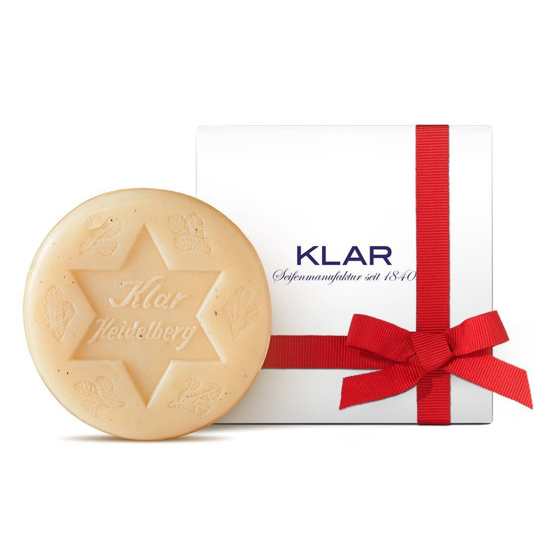 Savon rond avec motif étoile et inscription. Coffret cadeau blanc avec ruban rouge et inscription KLAR.
