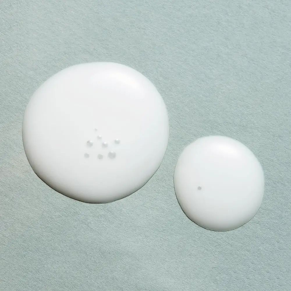 Twee witte druppels op lichtblauwe achtergrond. Kleinere druppel met één punt, grotere druppel met meerdere punten.