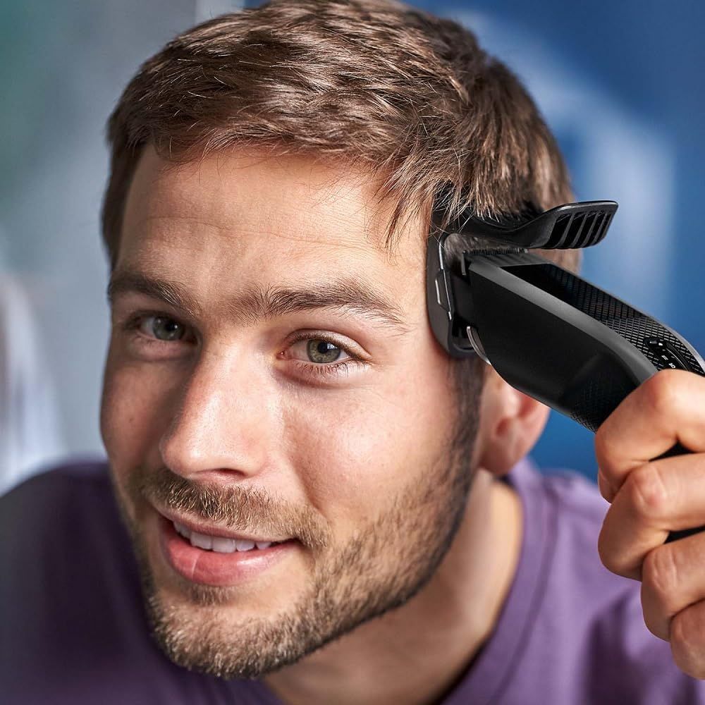 Man met Philips haartrimmer bij het hoofd. Close-up.