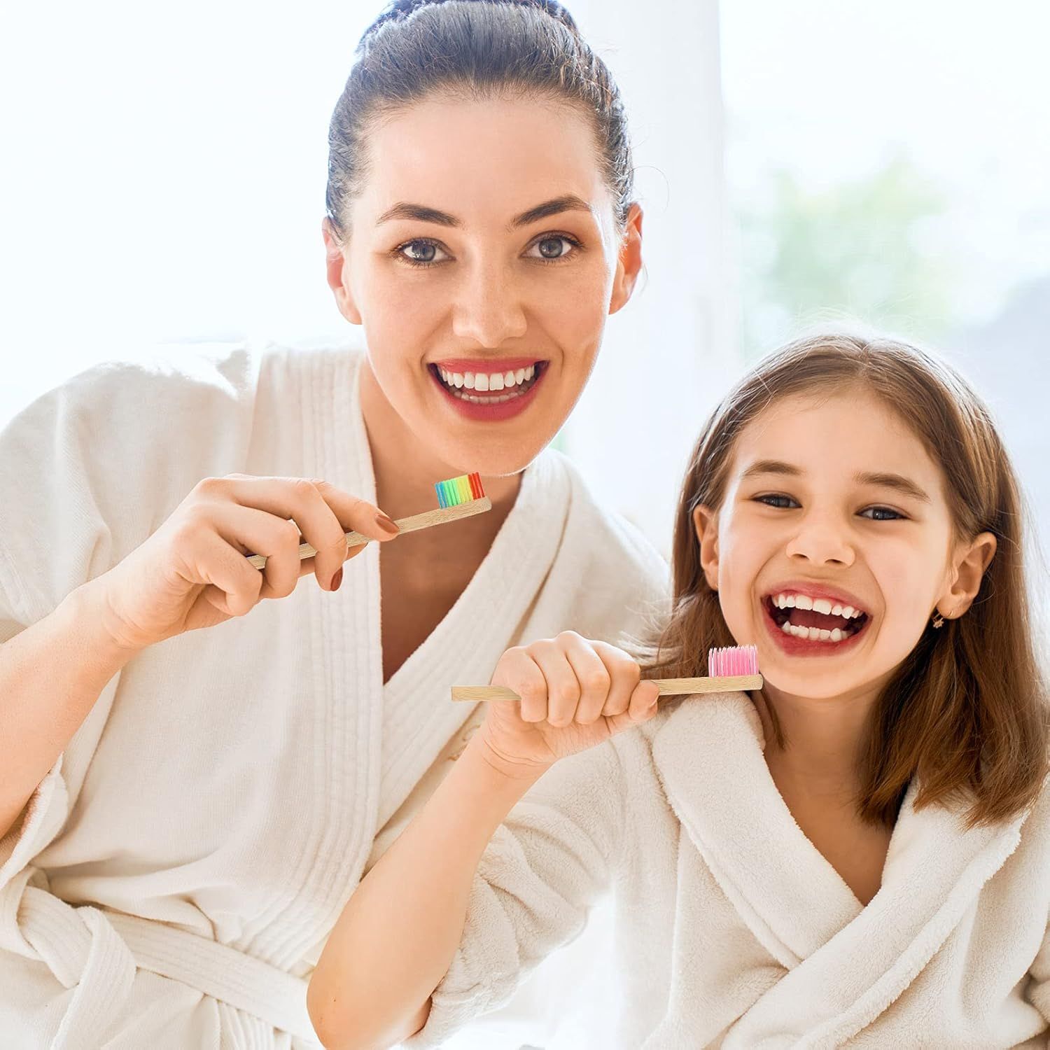 Femme et enfant se brossent les dents avec des brosses à dents en bambou.