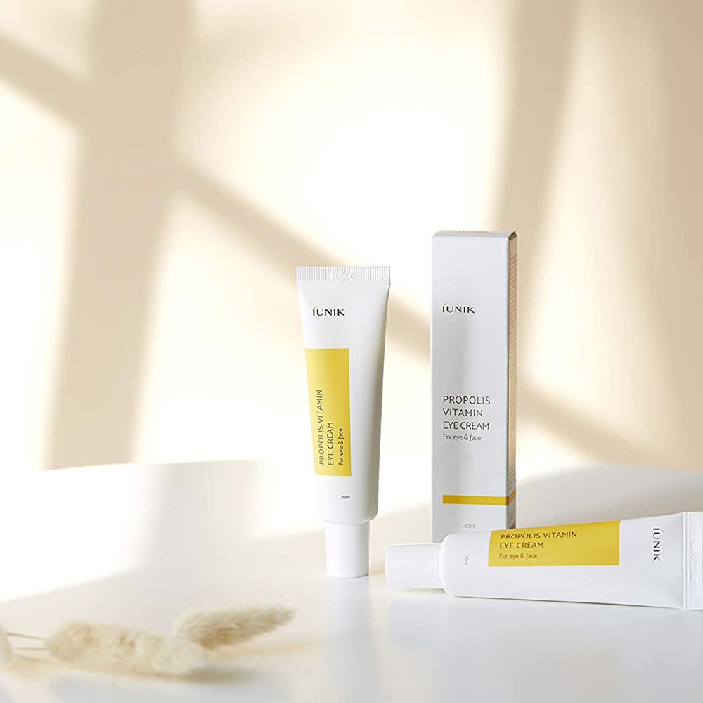 Trois tubes et une boîte. Inscription: PROPOLIS VITAMIN EYE CREAM, iUNIK. Emballage blanc avec étiquettes jaunes.