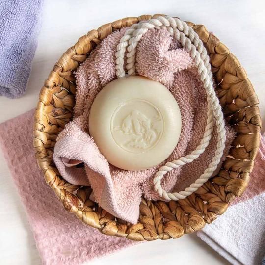 Savon rond avec cordon dans un panier avec des serviettes. Savon avec gravure.