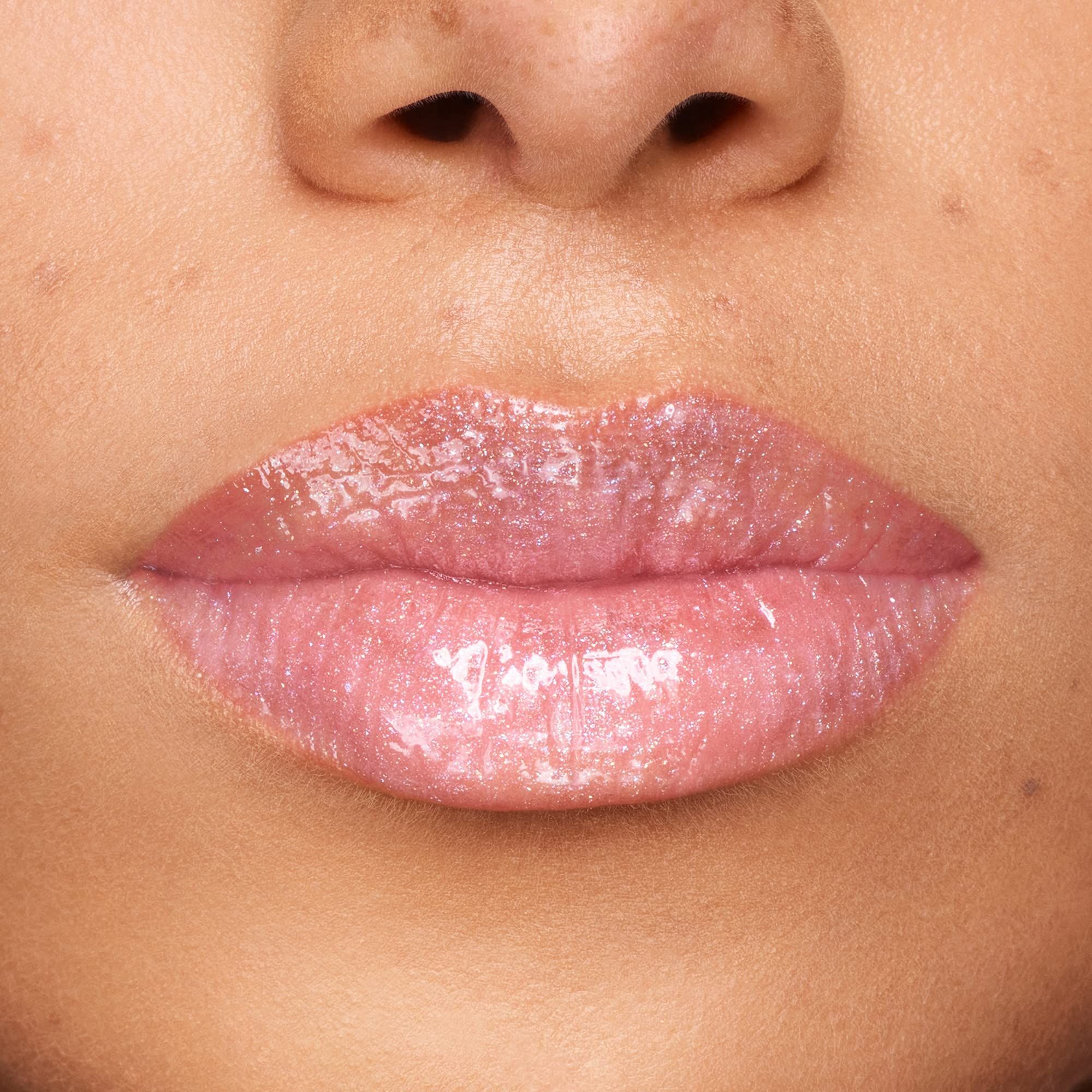 Close-up van lippen met glanzende lipgloss. Roze tint, glanzende finish.