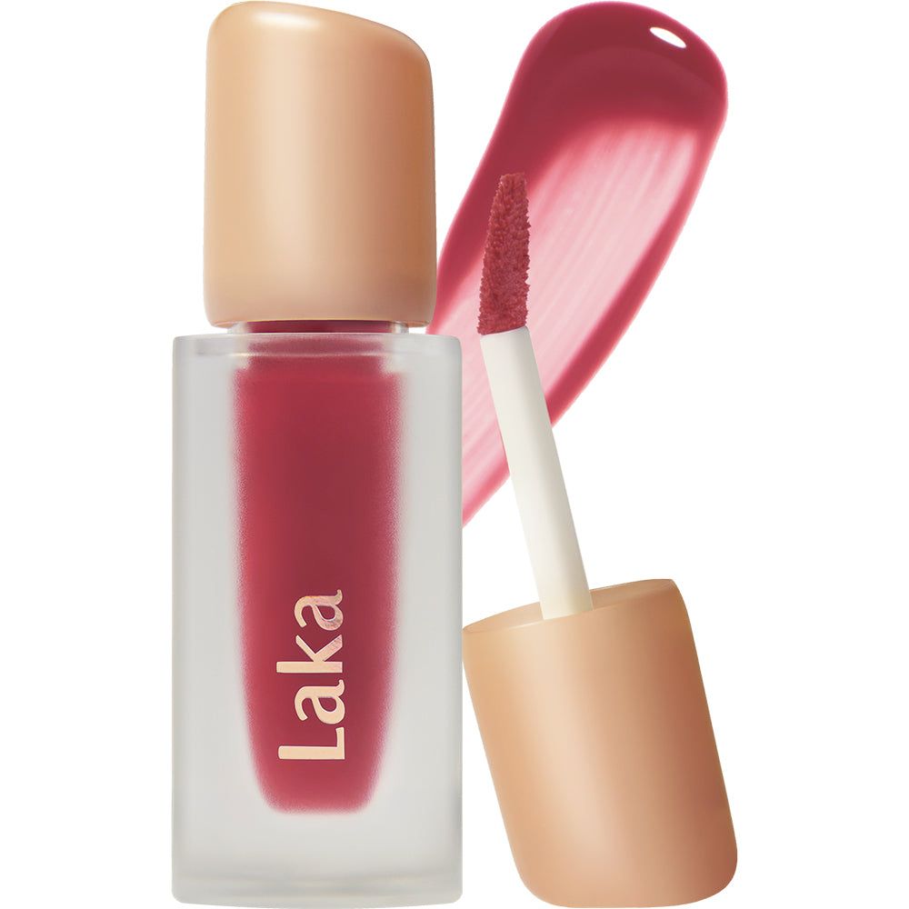 Laka lippenstift in matglazen flesje met beige dop en applicator. Rode lippenstiftveeg ernaast.