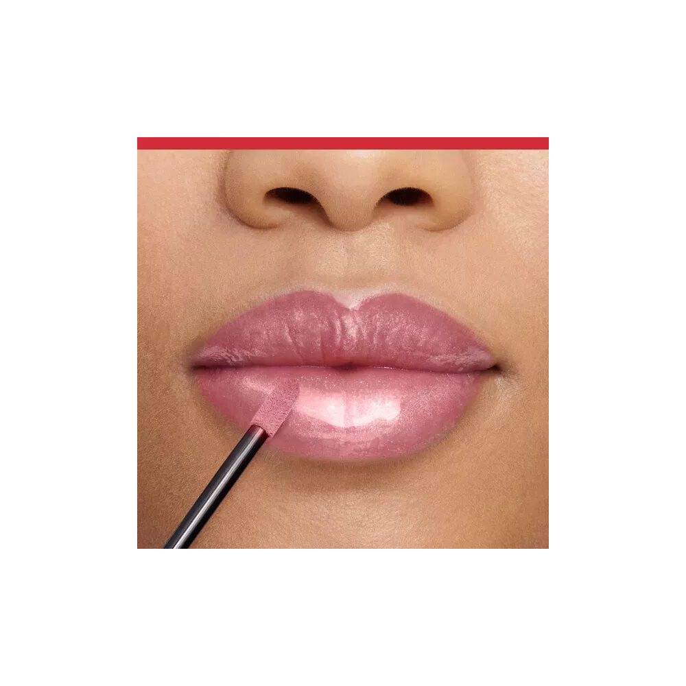 Gros plan sur des lèvres avec du gloss appliqué. Applicateur en cours d'utilisation.