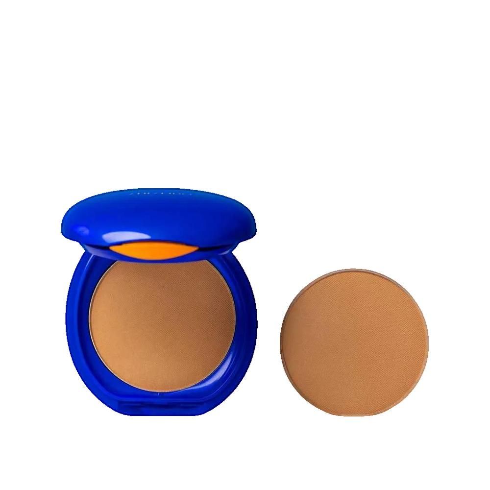 Compact poeder met blauw deksel, open. Daarnaast een ronde poeder. Lichte huidskleur.