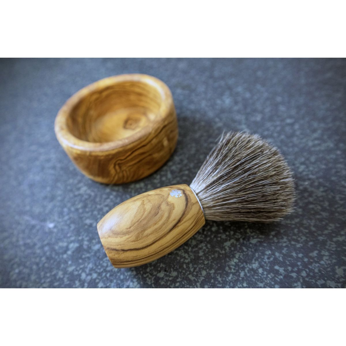 Olijfhouten scheerkwast met houten kom. Beide op donkere ondergrond.