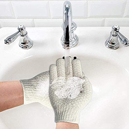 Deux gants de bain exfoliants gris clair avec poignets côtelés, posés sur un lavabo blanc.