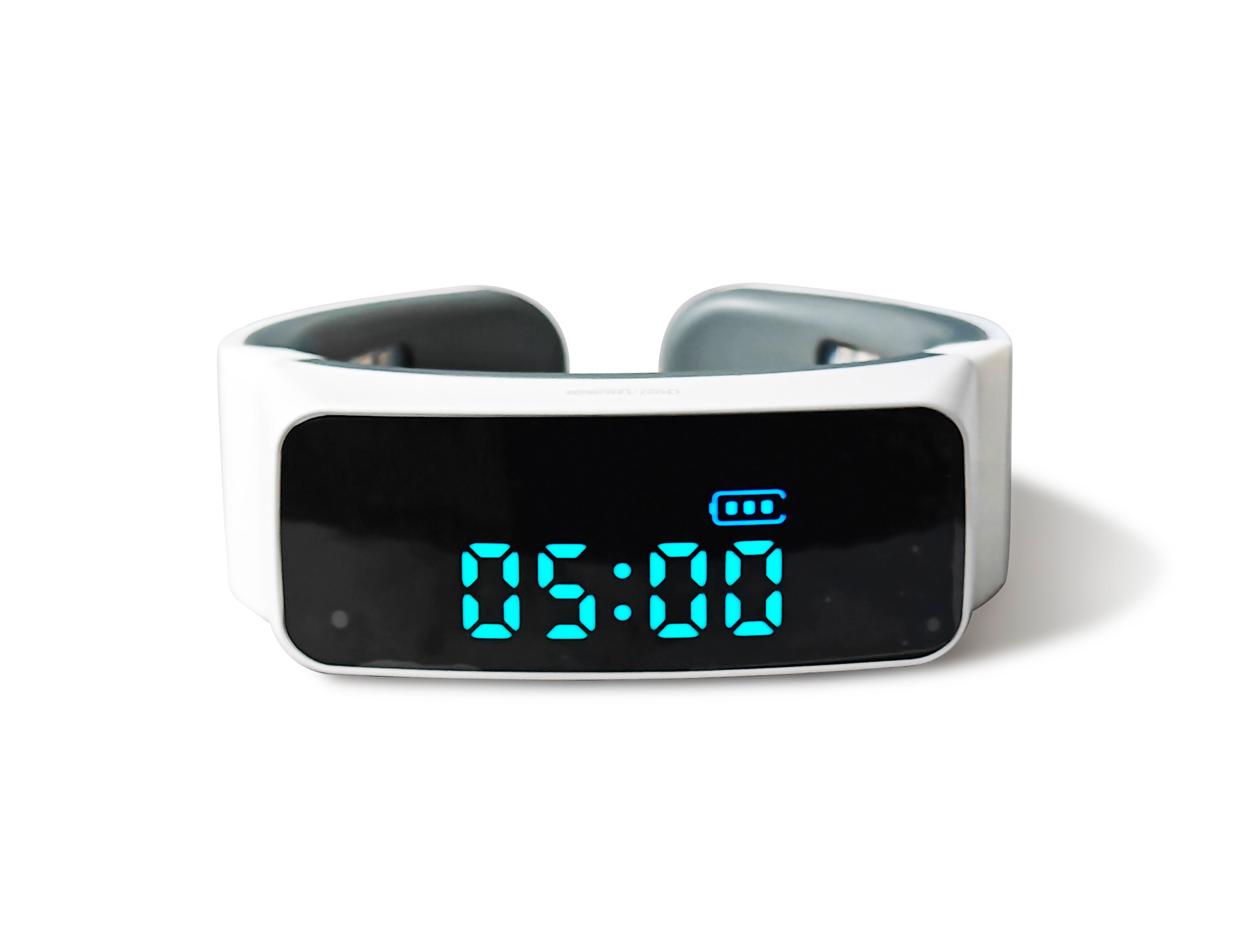 Appareil avec affichage numérique. Boîtier blanc, éléments gris. Affiche l'heure 05:00 et un indicateur de batterie.