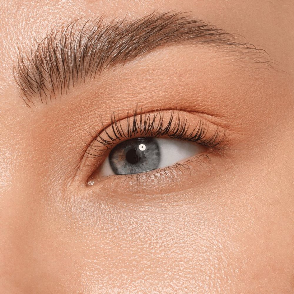 Gros plan sur un œil avec du mascara. La peau est claire et lisse. L'œil est bleu.