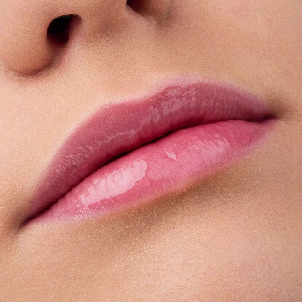 Close-up van lippen met lipolie. Roze tint, glanzend.