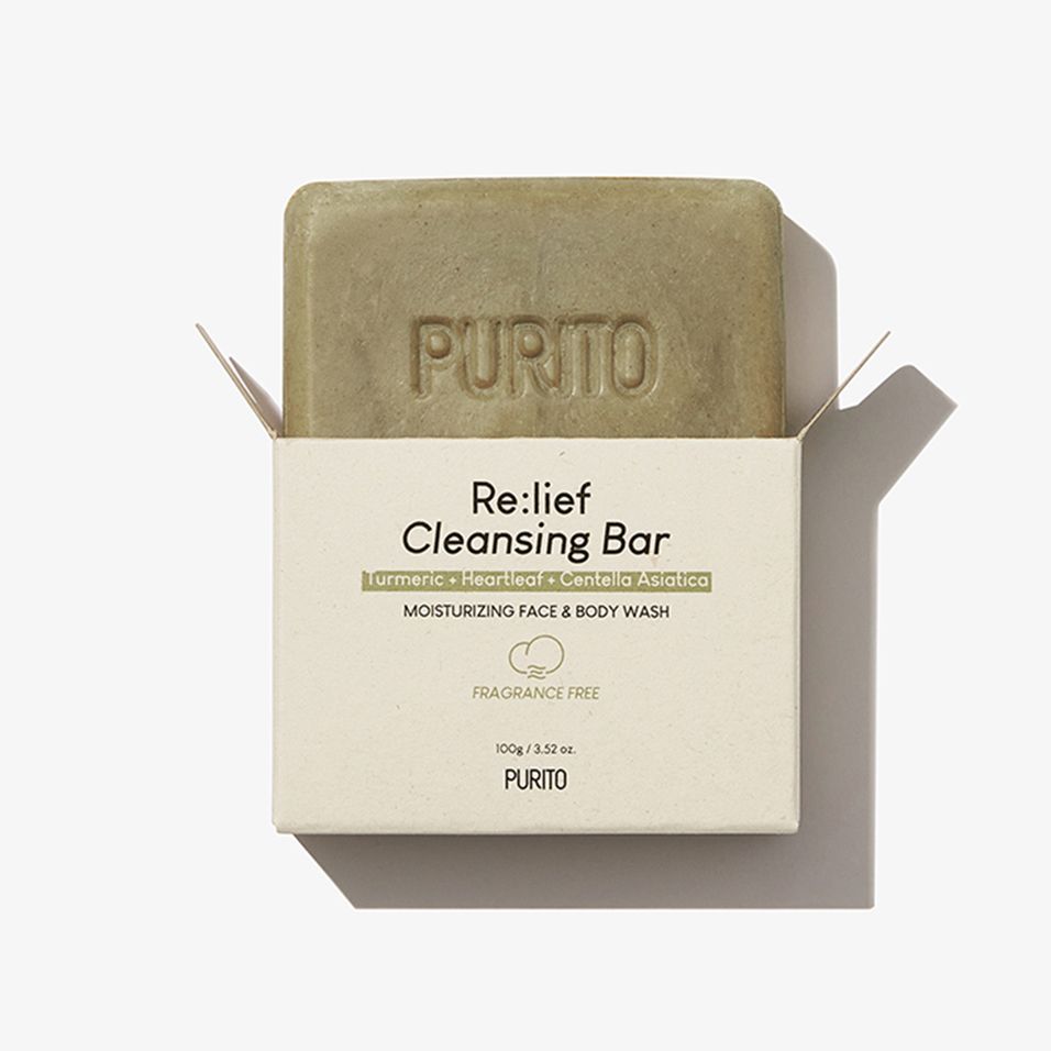 Savon dans son emballage ouvert. L'emballage porte l'inscription « Re:lief Cleansing Bar » et « PURITO ».