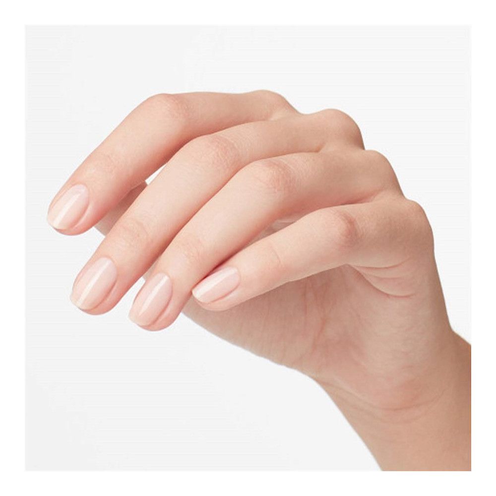 Main avec ongles vernis. Vernis à ongles rose clair.