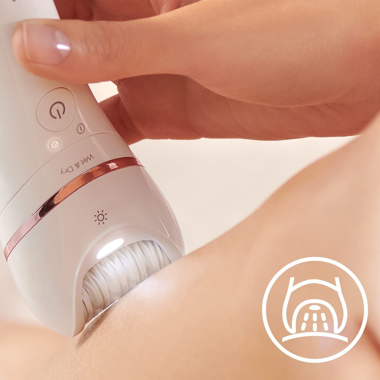 Gros plan : épilateur en cours d'utilisation. Épilateur blanc, accents or rose. Peau, lumière.