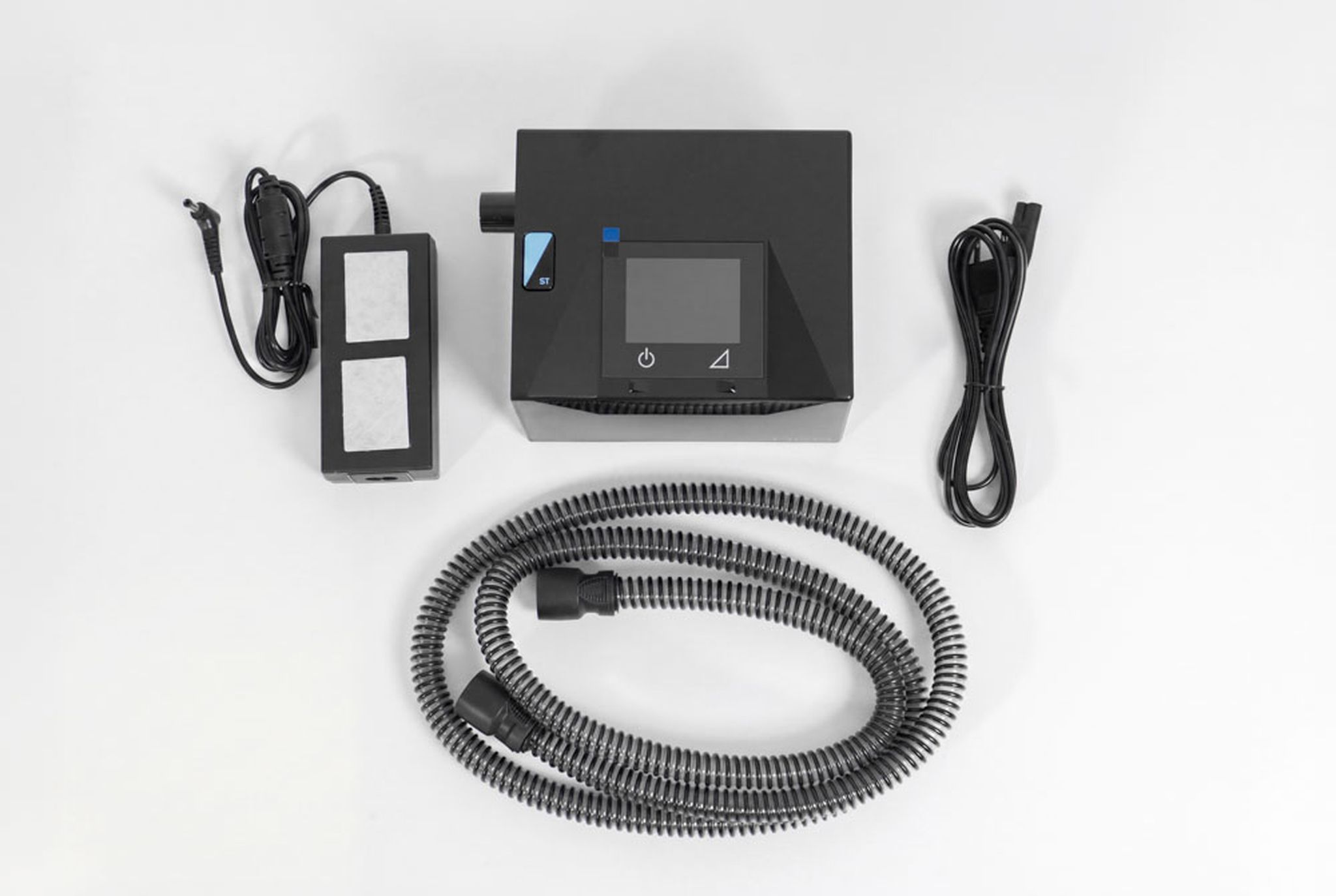Sefam Néa DUO ST apparaat met accessoires: adapter, slang, kabel en filter.