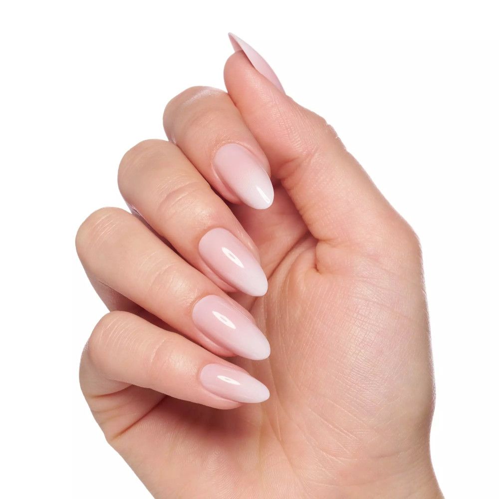 Main avec faux ongles roses pointus. Dégradé de rose à blanc. Pas d'emballage visible.