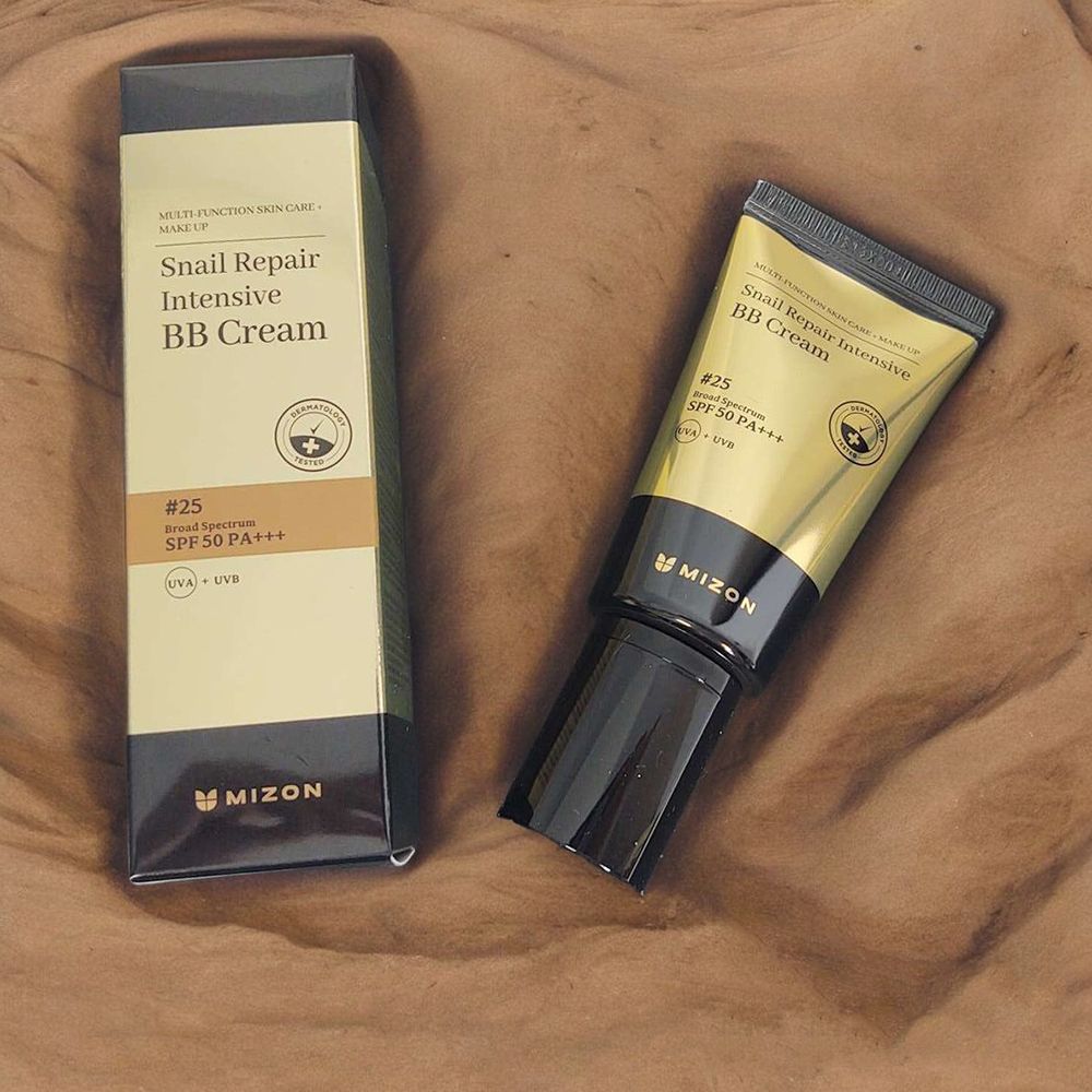 Tube en doos van BB Cream. Opschrift: Snail Repair Intensive BB Cream. Merk MIZON. Op bruine achtergrond.