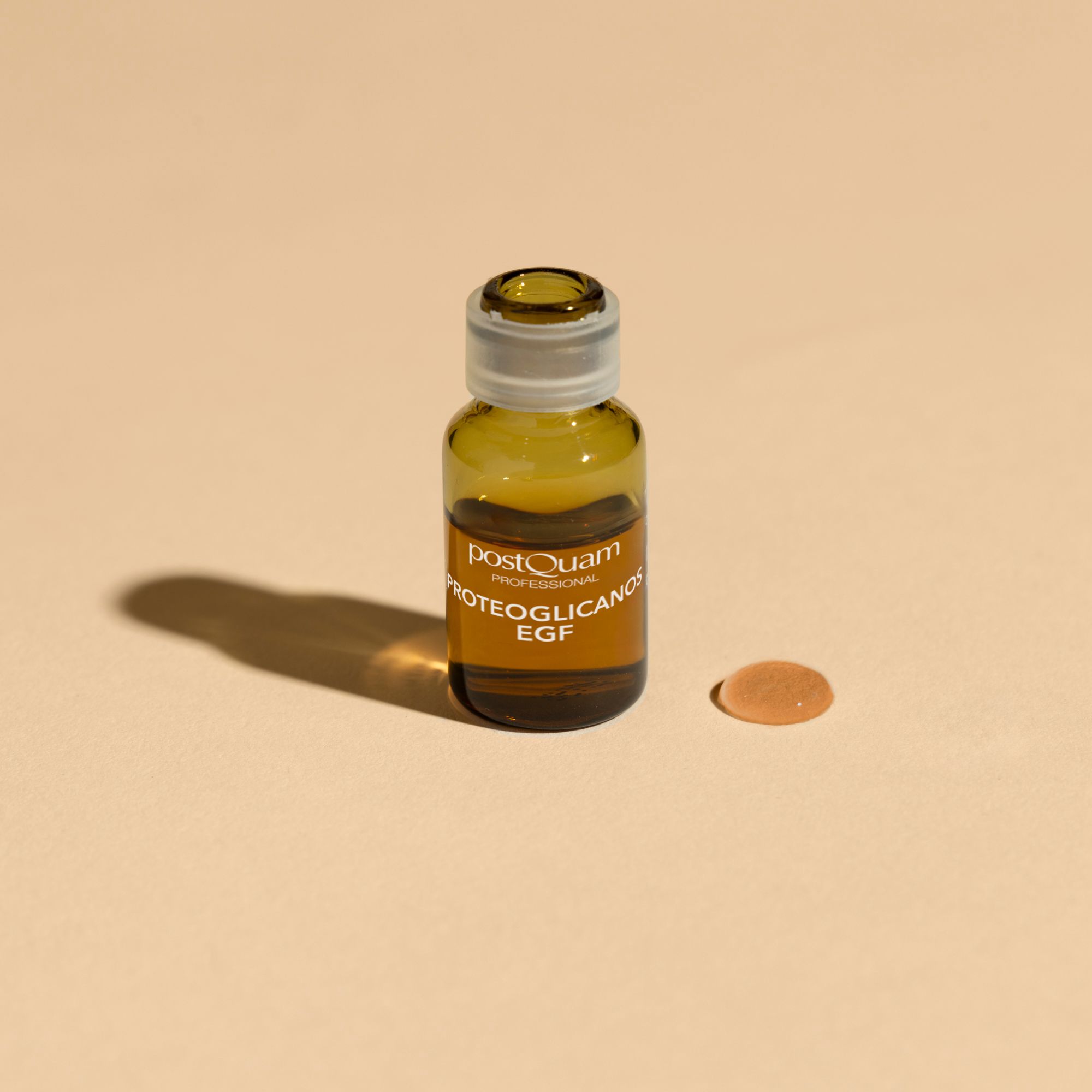 Ampoule en verre brun avec l'inscription PROTEOGLICANOS EGF. À côté, une petite tache ronde.