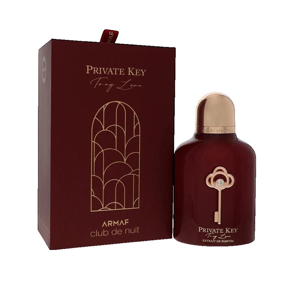 Donkerrode flacon met gouden dop en sleuteldecoratie. Daarnaast een bijpassende doos met gouden tekst.