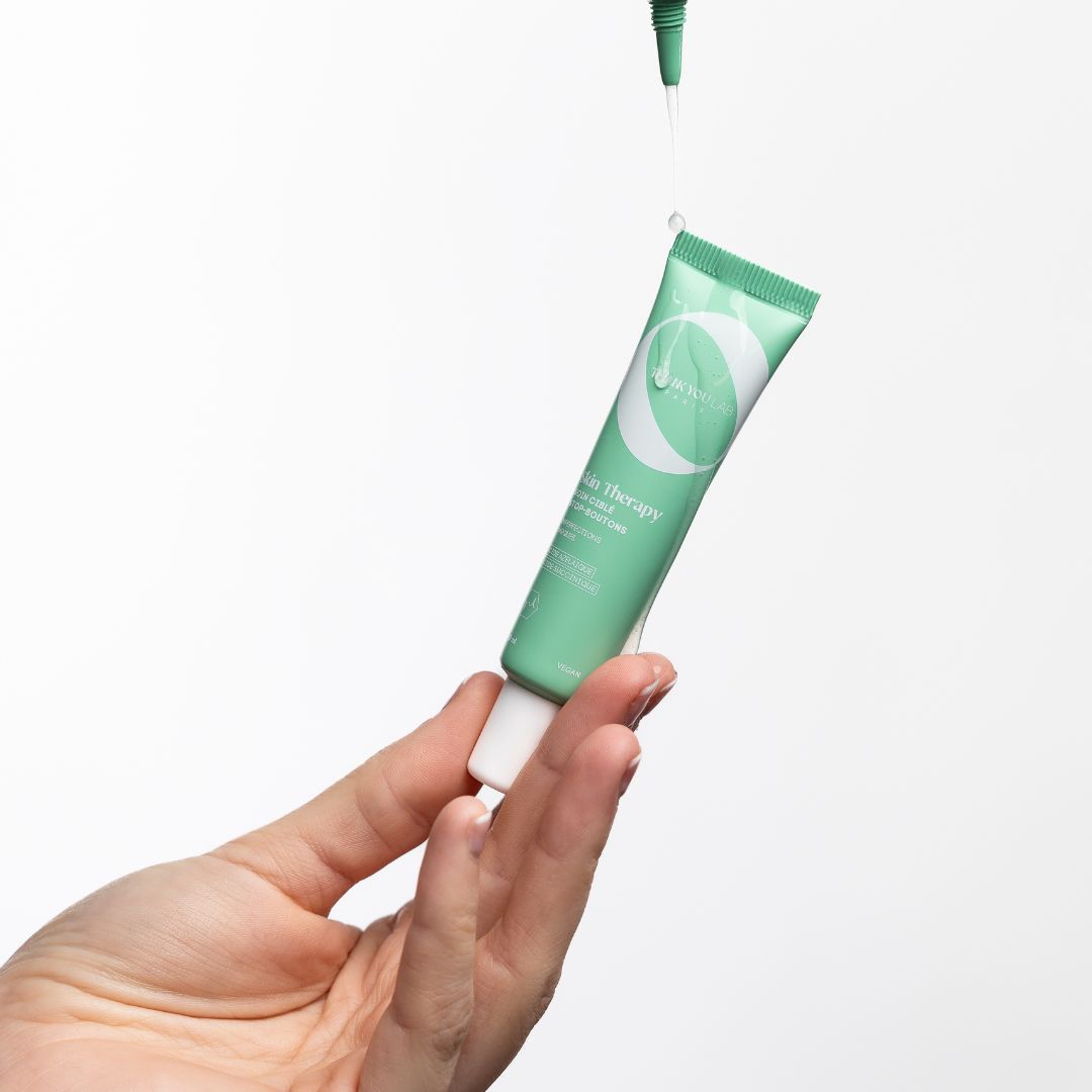 Tube vert, goutte. Produit tenu. Texte: Skin Therapy, Cure & Routine.
