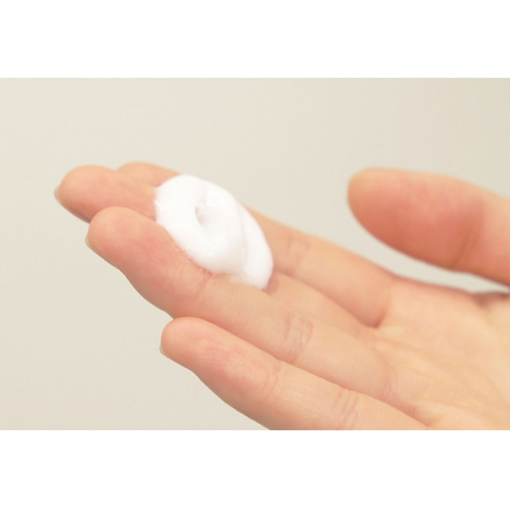 Witte, romige substantie op een handpalm. Close-up.