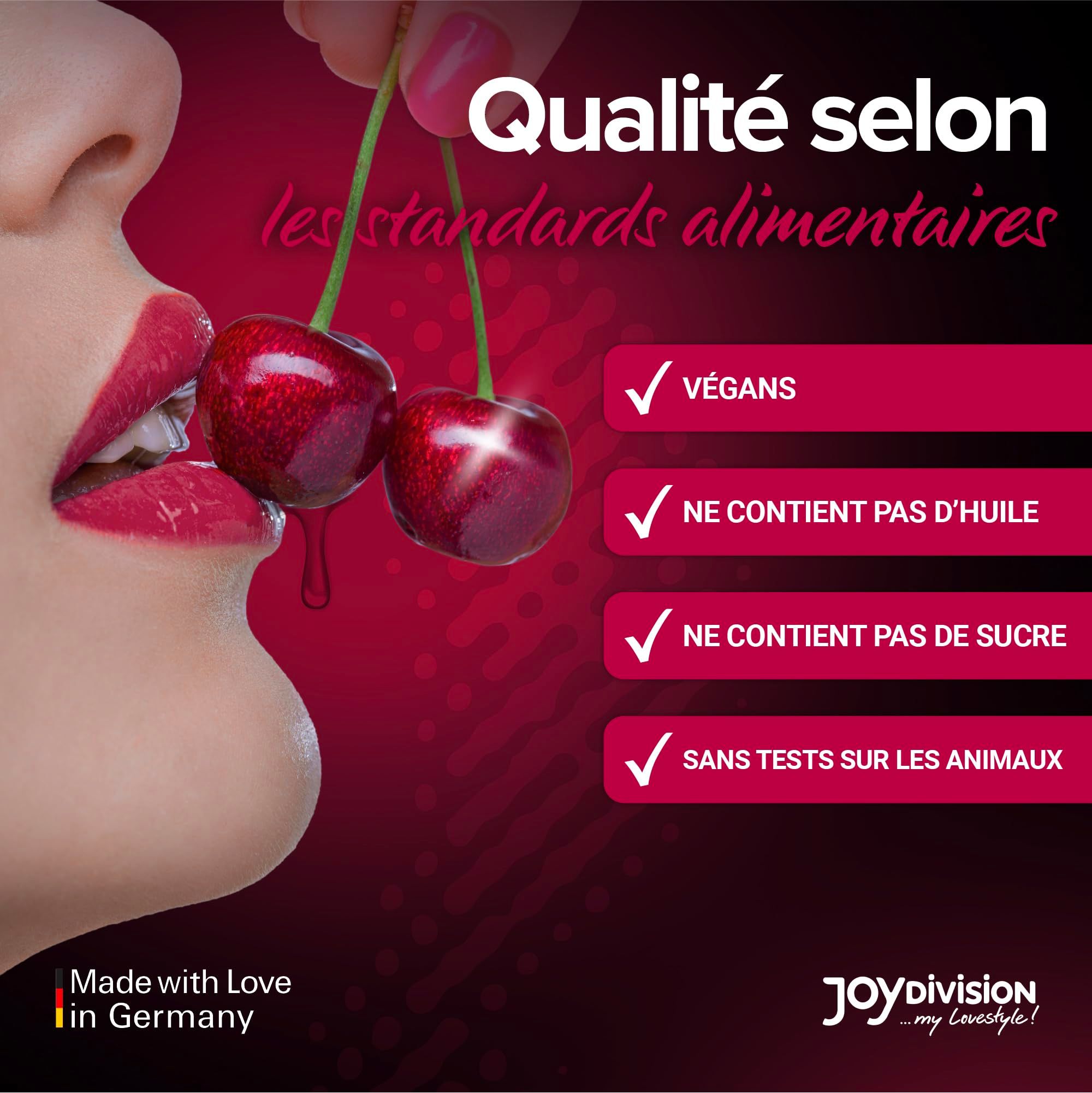 Bouteille d'huile de massage à la cerise, avec des cerises et des éclaboussures.