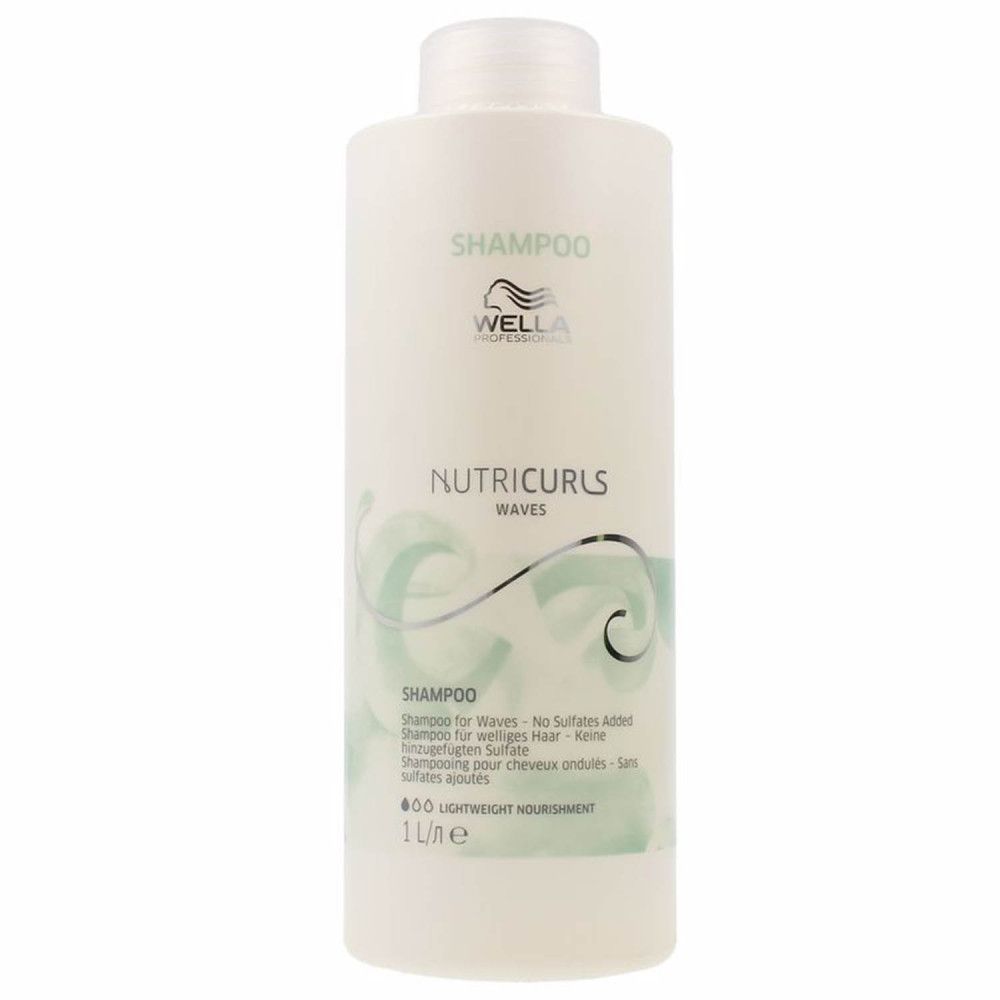 Flacon de shampooing blanc avec SHAMPOO, WELLA, NUTRUCURLS WAVES. Flacon de 1 litre. Texte: Shampooing pour cheveux ondulés - sans sulfates ajoutés.