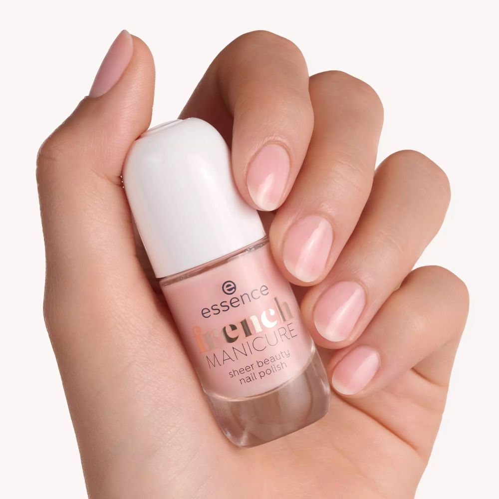 Main tenant un flacon de vernis à ongles. Inscription : essence french MANICURE sheer beauty nail polish. Ongles vernis.