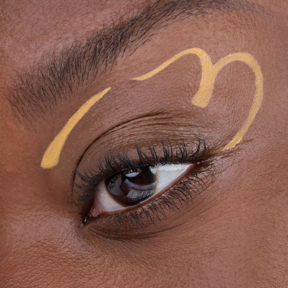 Œil avec un design d'eye-liner jaune. Le design est en forme de cœur.