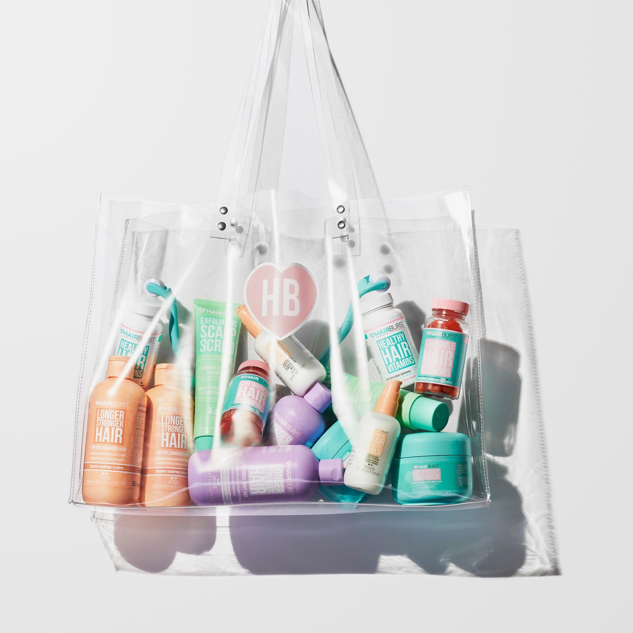 Sac transparent rempli de divers produits capillaires. Un cœur avec "HB" est imprimé sur le sac.