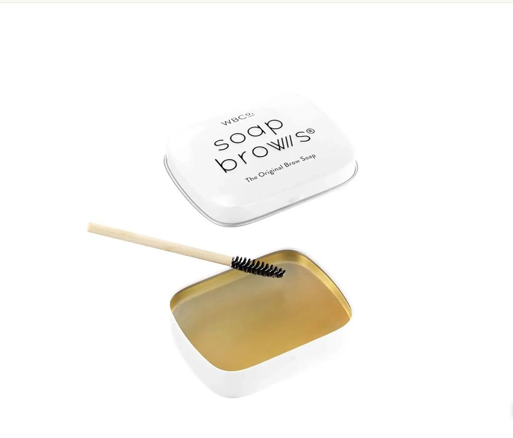 Witte, vierkante doos met tekst. Daaronder een open doosje met borstel.