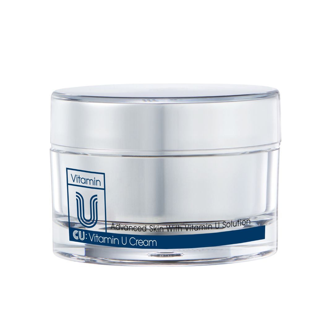 Pot de crème avec couvercle. Inscription "Vitamin U" et "CU: Vitamin U Cream". Texte bleu sur fond blanc.