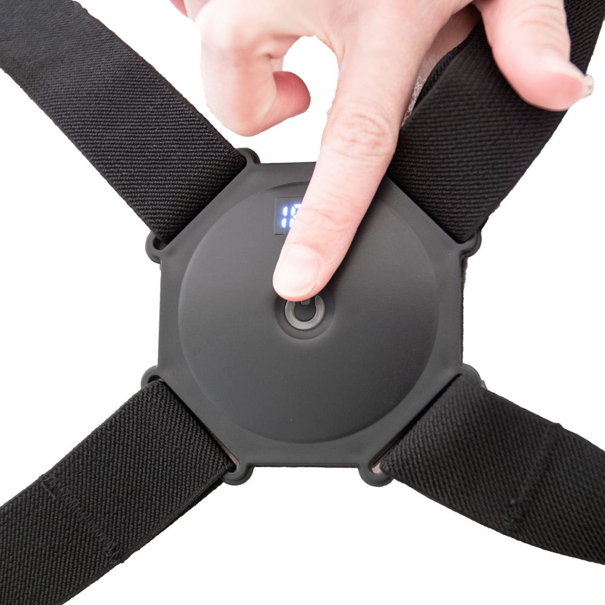 Gros plan sur le correcteur de posture noir. Doigt appuyant sur le bouton du module.