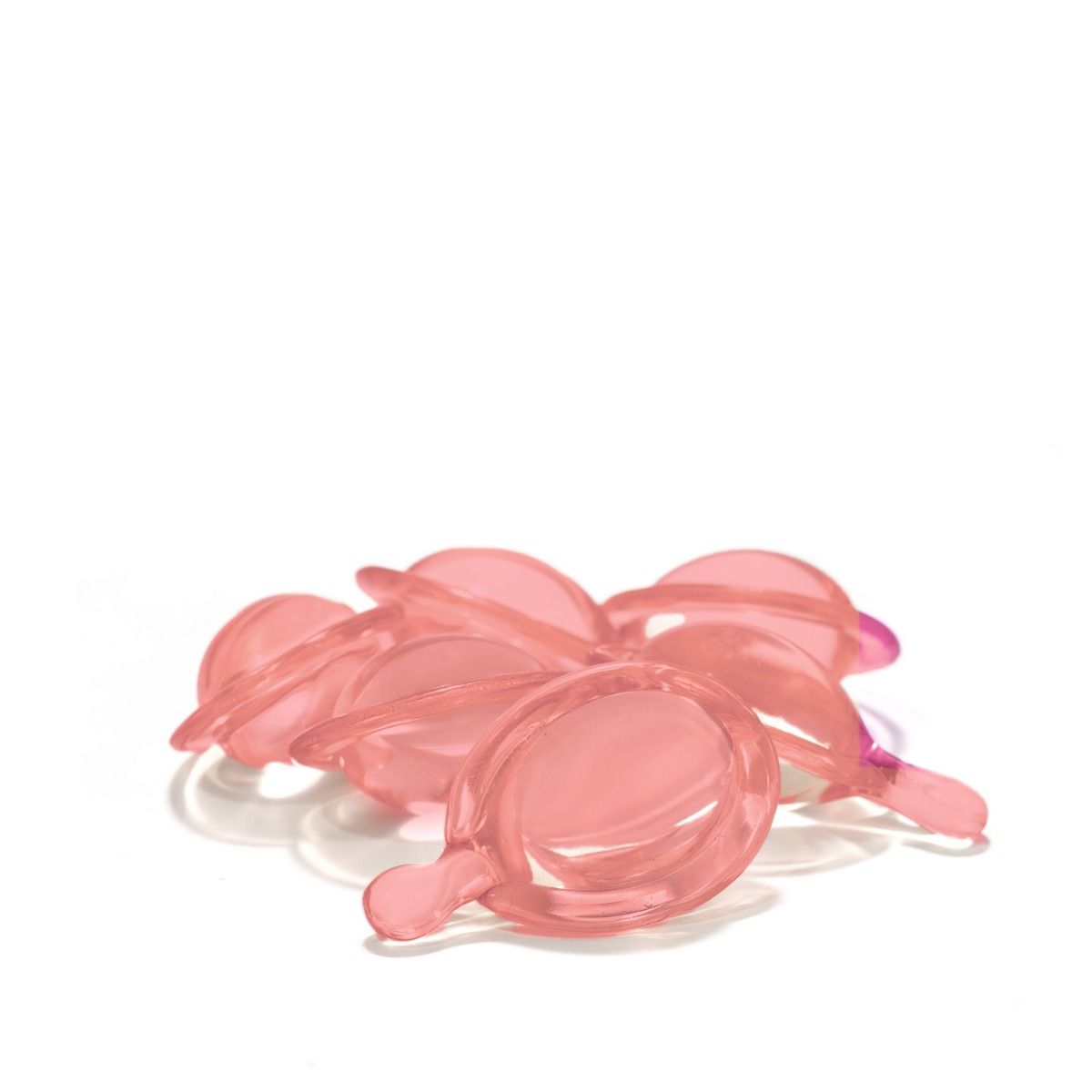 Meerdere roze, druppelvormige capsules met een klein handvat. Op witte achtergrond.