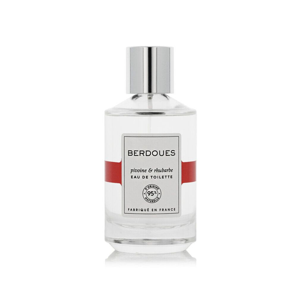 Flacon de parfum avec bouchon argenté et bande rouge. Texte sur étiquette blanche.