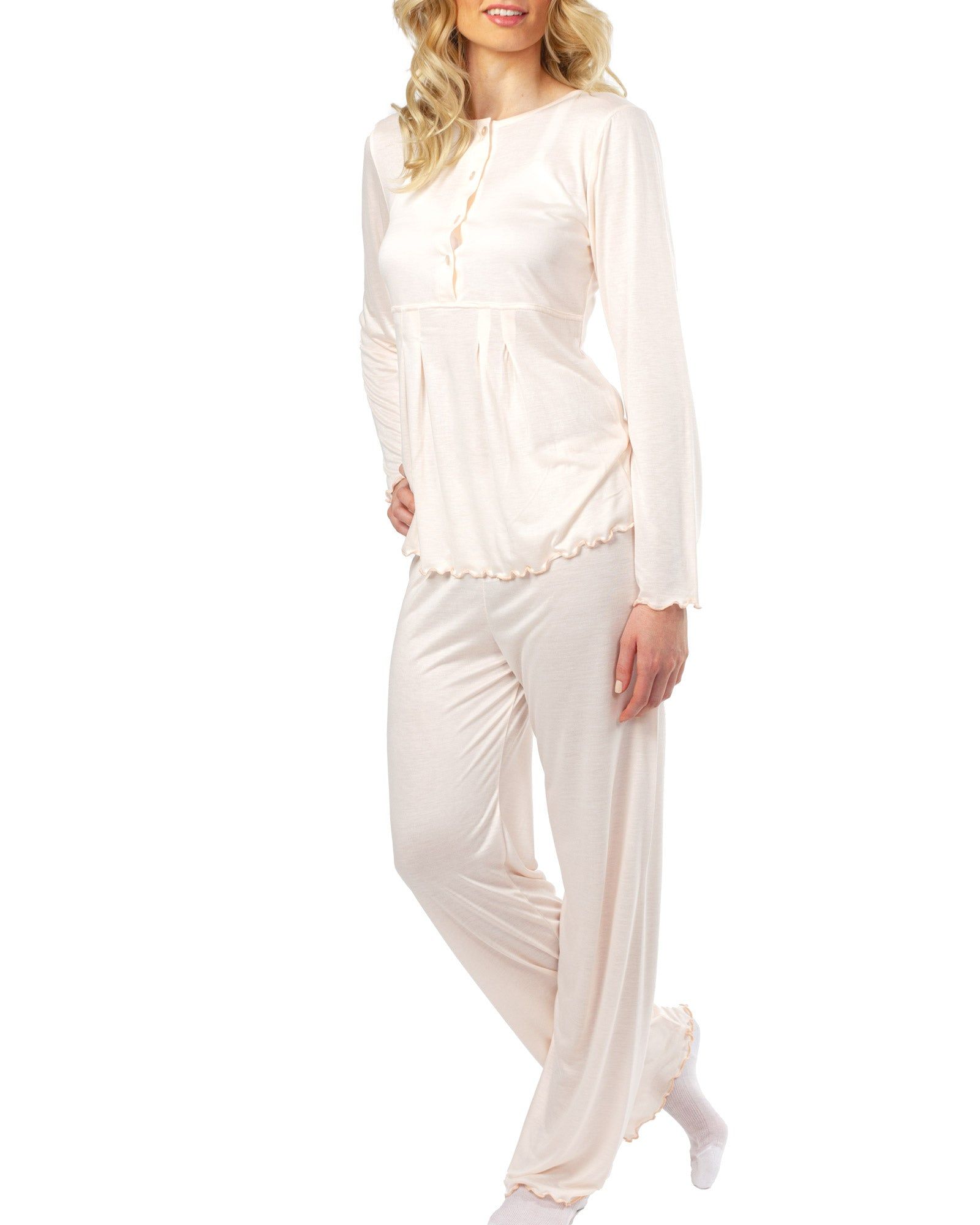 Ensemble de pyjama rose. Haut à manches longues avec boutons, ourlet à volants. Pantalon long. Femme portant l'ensemble.