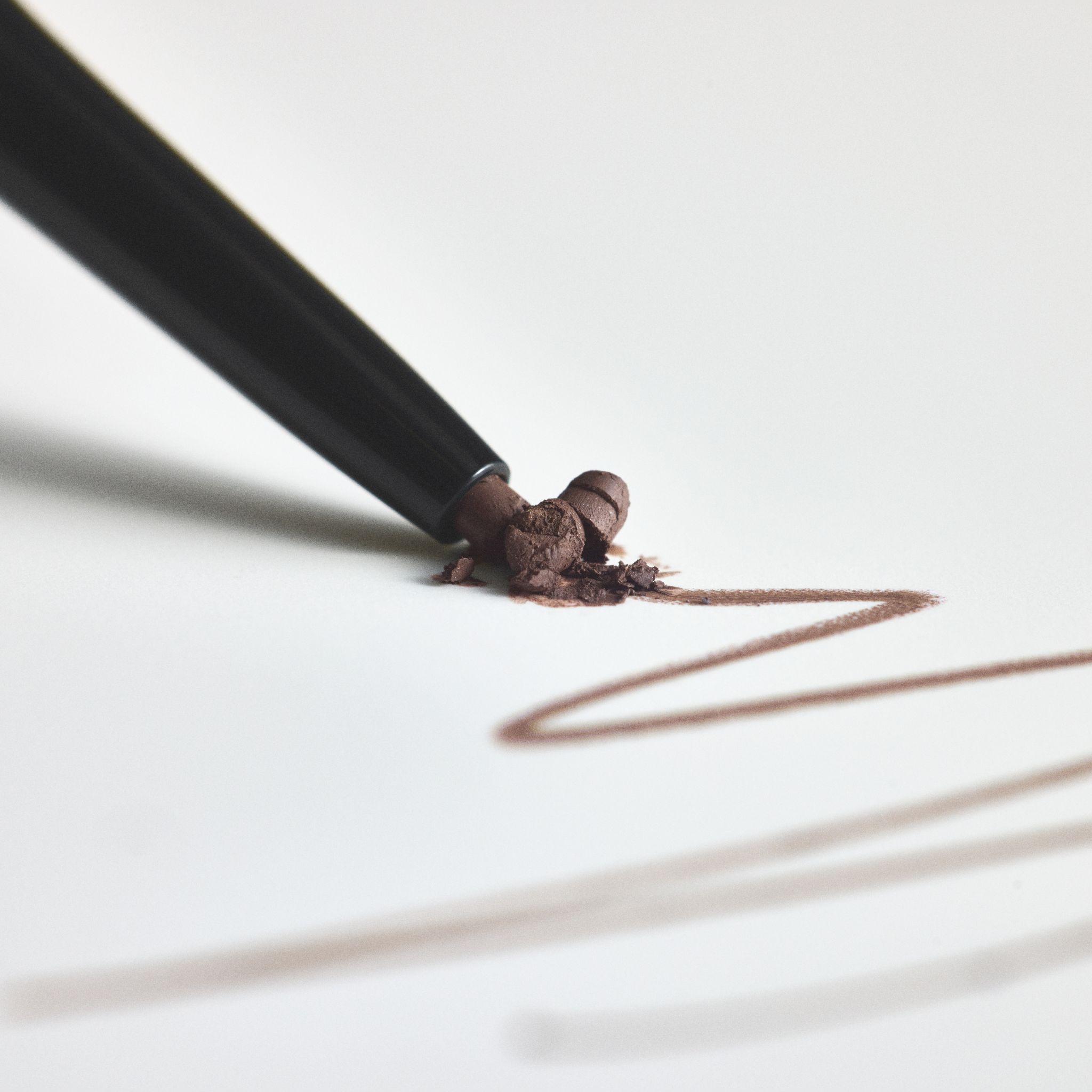 Crayon à sourcils RevitaLash Hi-Def, teinte Cool Brown, pointe sur papier blanc.