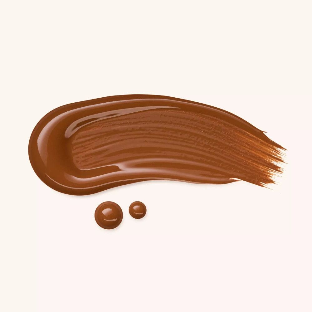 Trait de fond de teint marron avec deux gouttes. Sur fond clair.