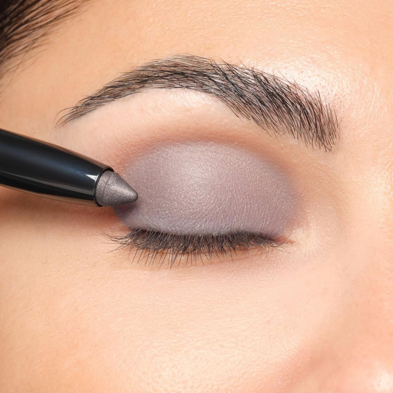 Œil avec fard à paupières appliqué. Artdeco High Performance Eyeshadow Stylo utilisé. Fard à paupières gris.