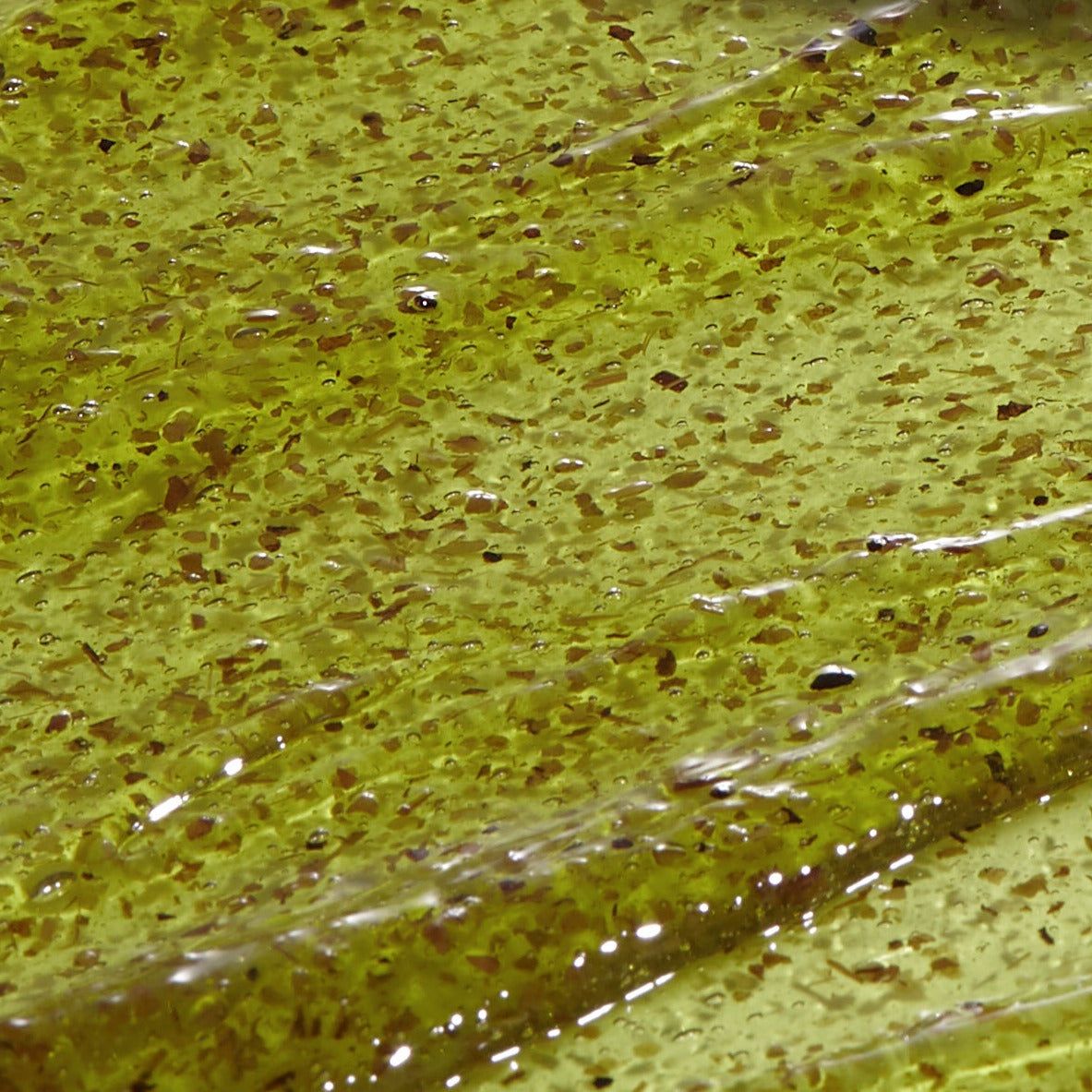 Close-up van gelmasker. Gel met groene deeltjes. Op glad oppervlak.