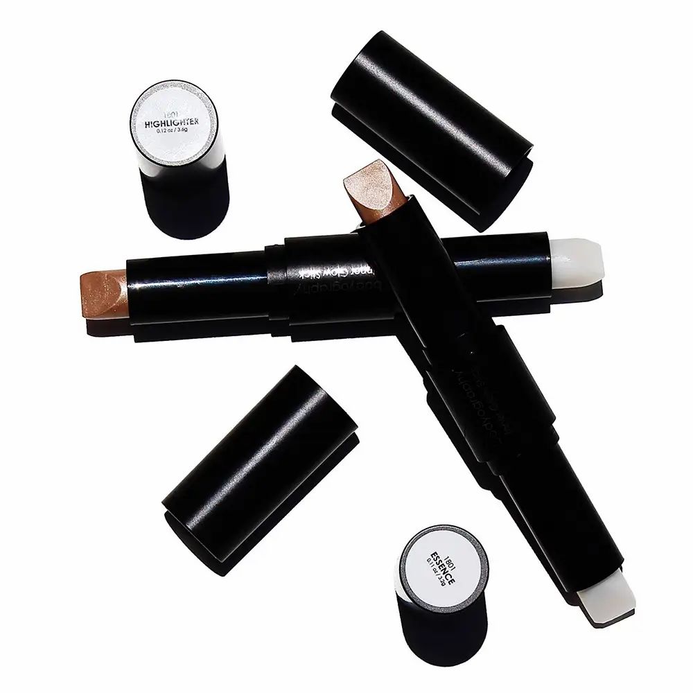 Meerdere highlighter sticks met open doppen. Eén kant licht, de andere champagne. Zwarte pennen.