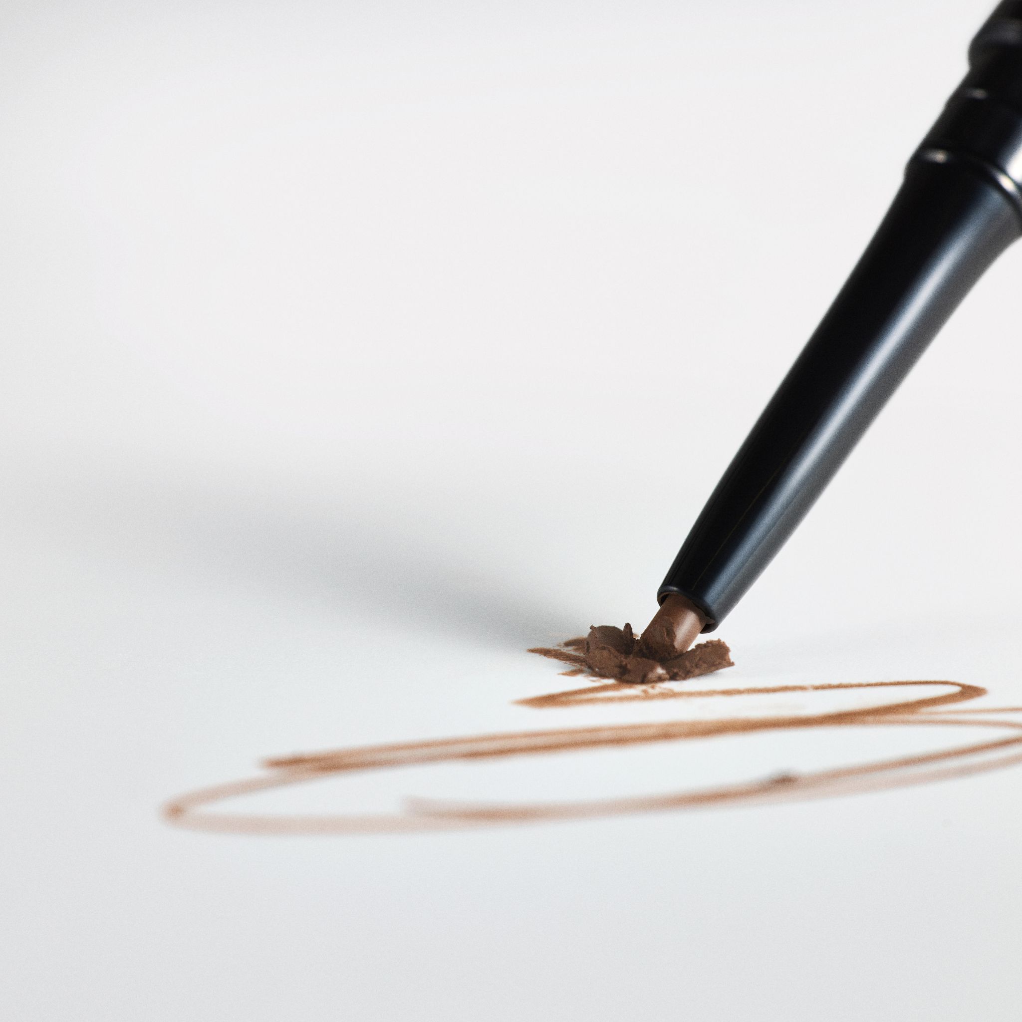 Crayon sourcils Hi-Def RevitaLash® Brun Chaud traçant une ligne.