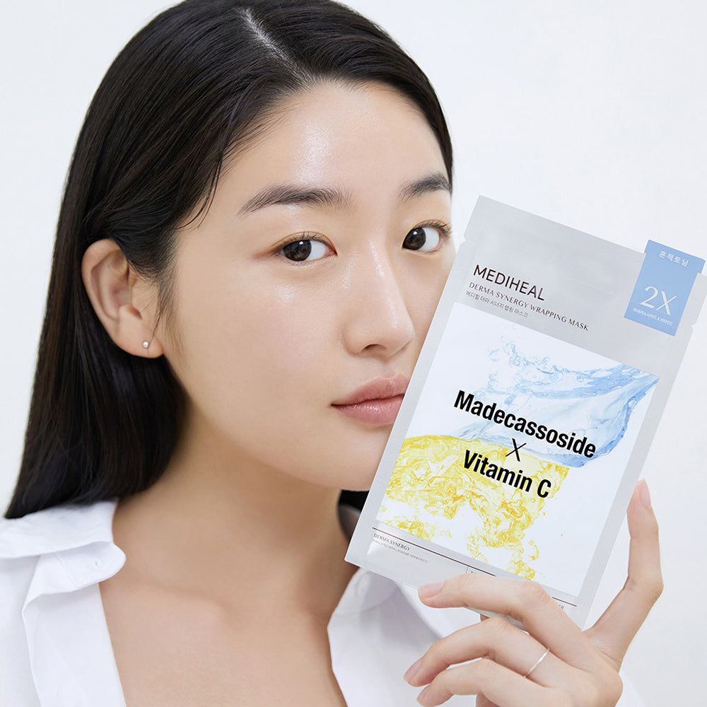 Vrouw houdt verpakking gezichtsmasker vast. Opschrift: Madecassoside X Vitamin C. Merk: MEDIHEAL Derma Synergy Wrapping Mask.