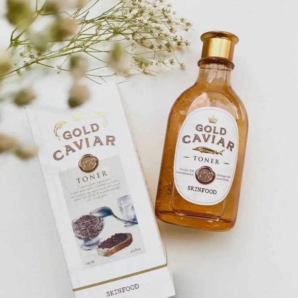 Flacon et emballage Gold Caviar Ex Toner. Flacon ambré, emballage blanc avec détails dorés. Logo SKINFOOD.