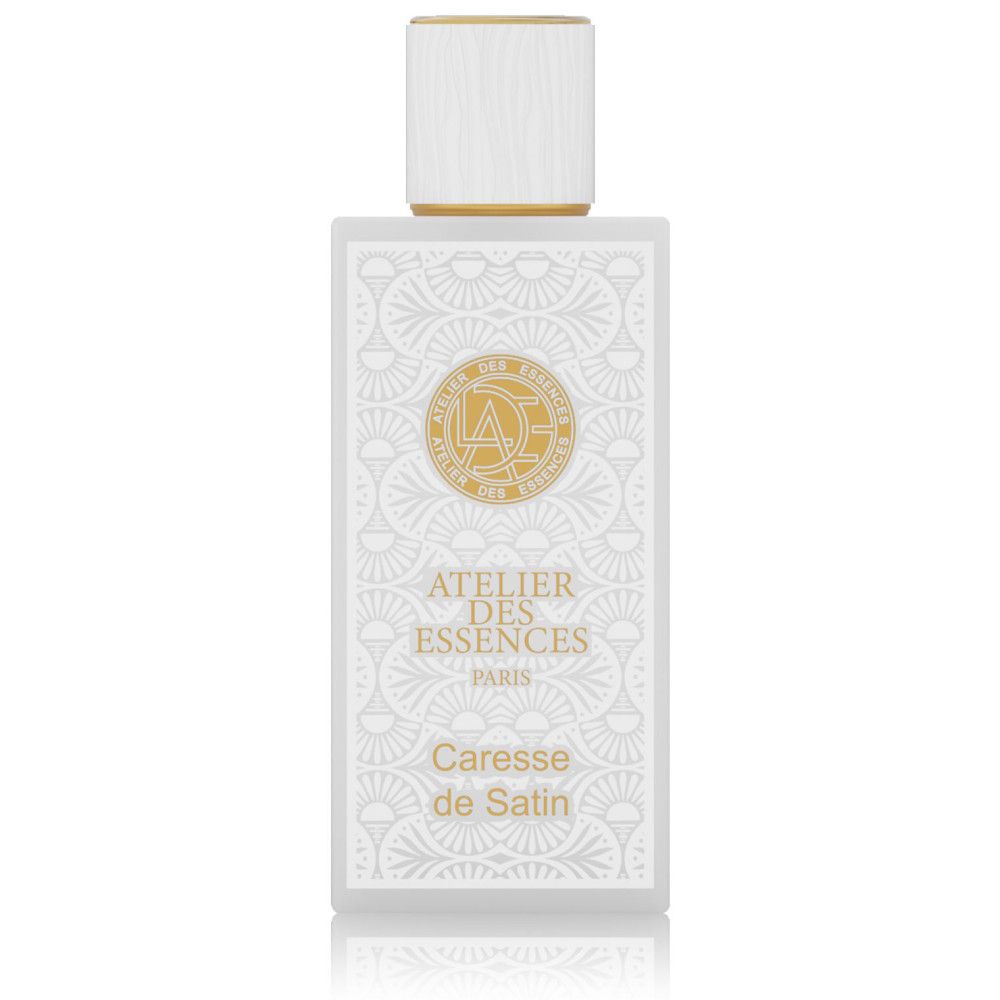 Flacon de parfum blanc avec détails dorés. Inscription : Atelier des Essences, Caresse de Satin.